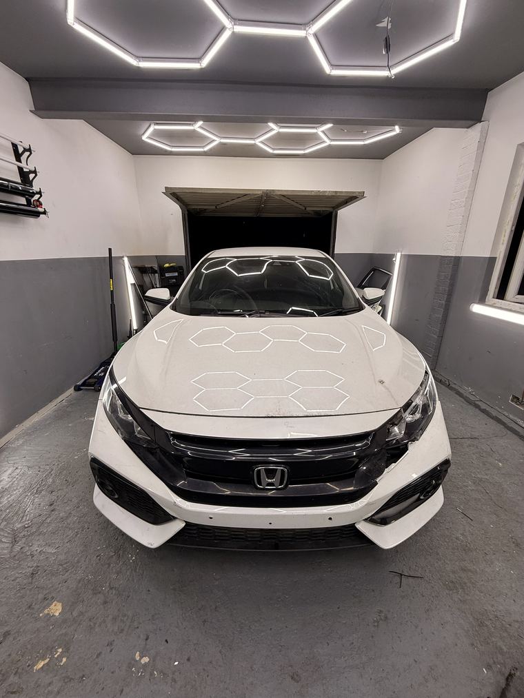 White Honda Civic mid-job with its front bumper removed