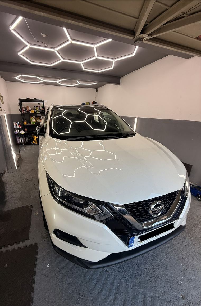White Nissan Qashqai parked under the workshop's hexagon lighting